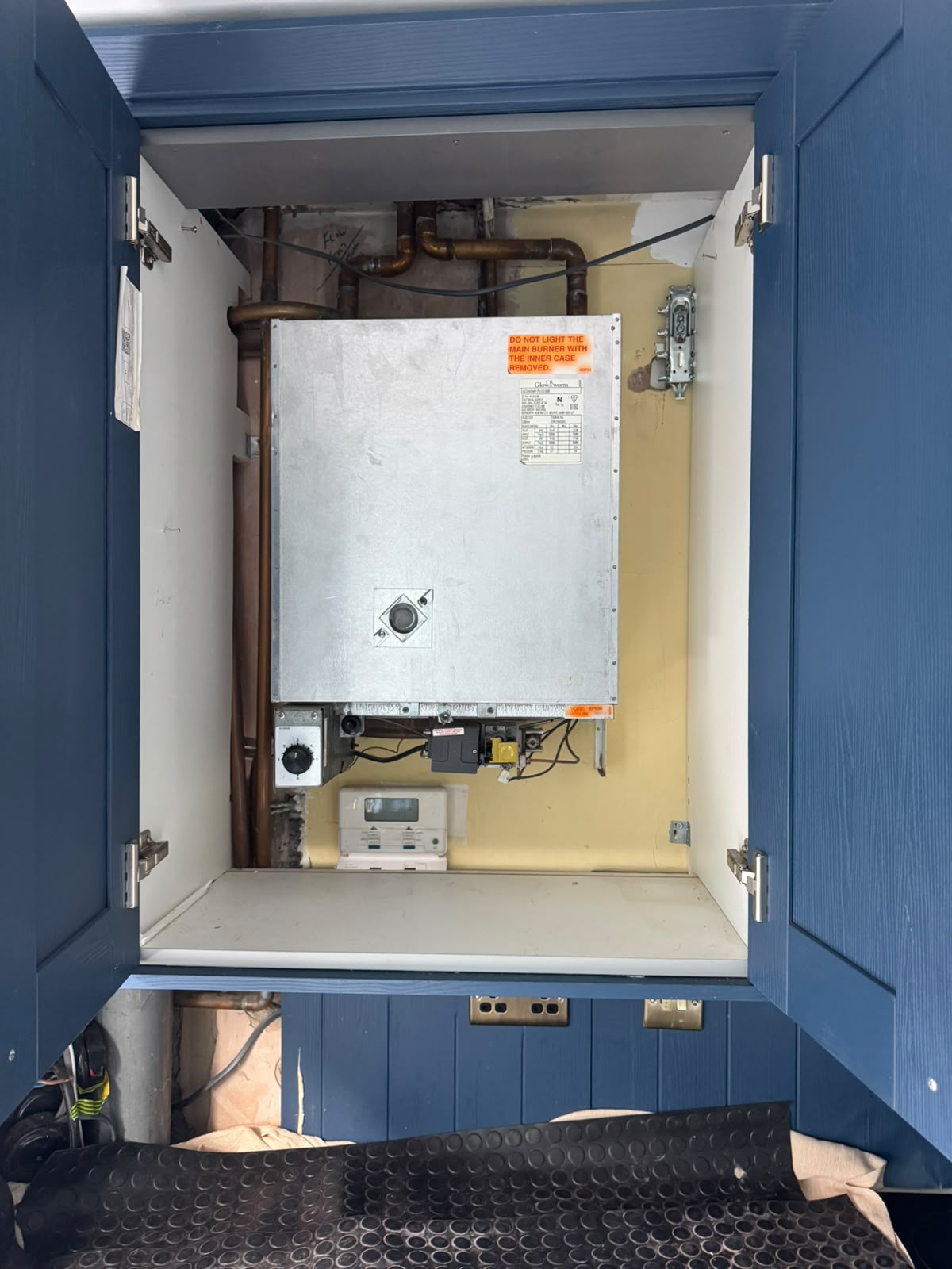 Before: Inefficient old boiler inside cupboard